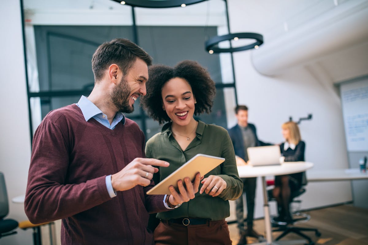 A male and a female business professional, smiling