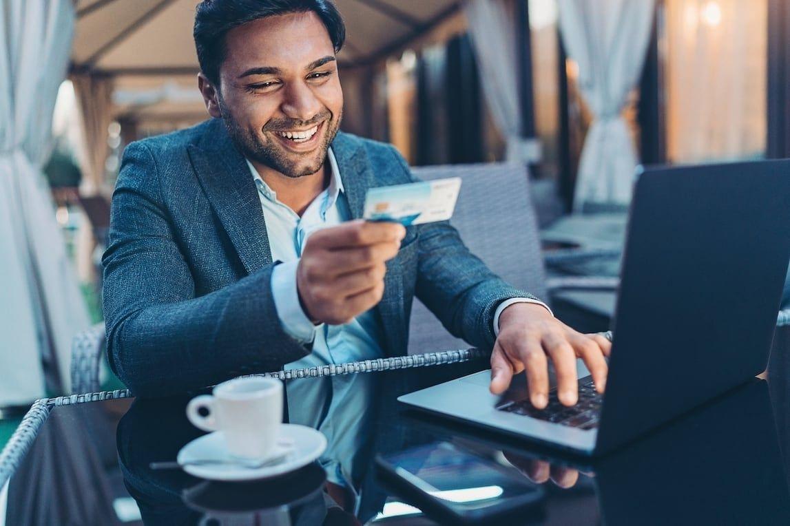 Happy person putting phone details into work computer