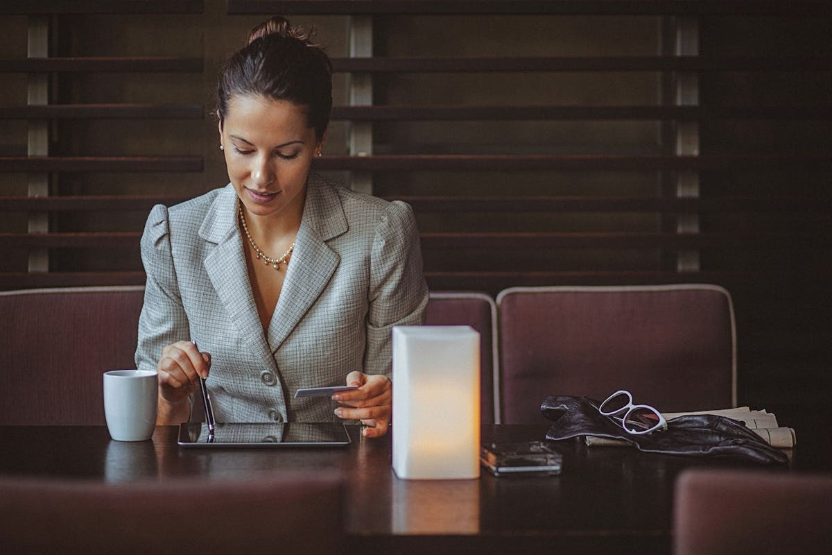 Woman on a tablet computer holding a credit card