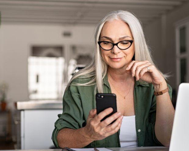 Person on phone using Emburse Tallie for expense reporting