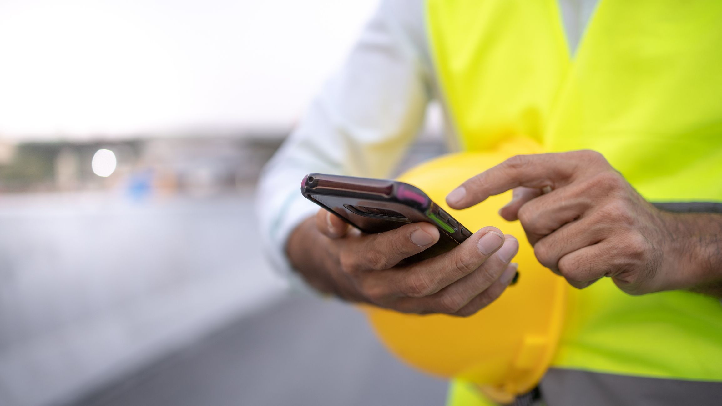 Man looking at phone on construction site 