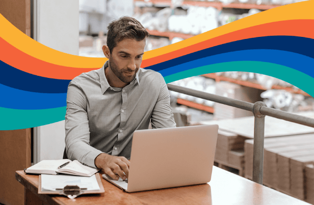 Man working in a warehouse on a laptop