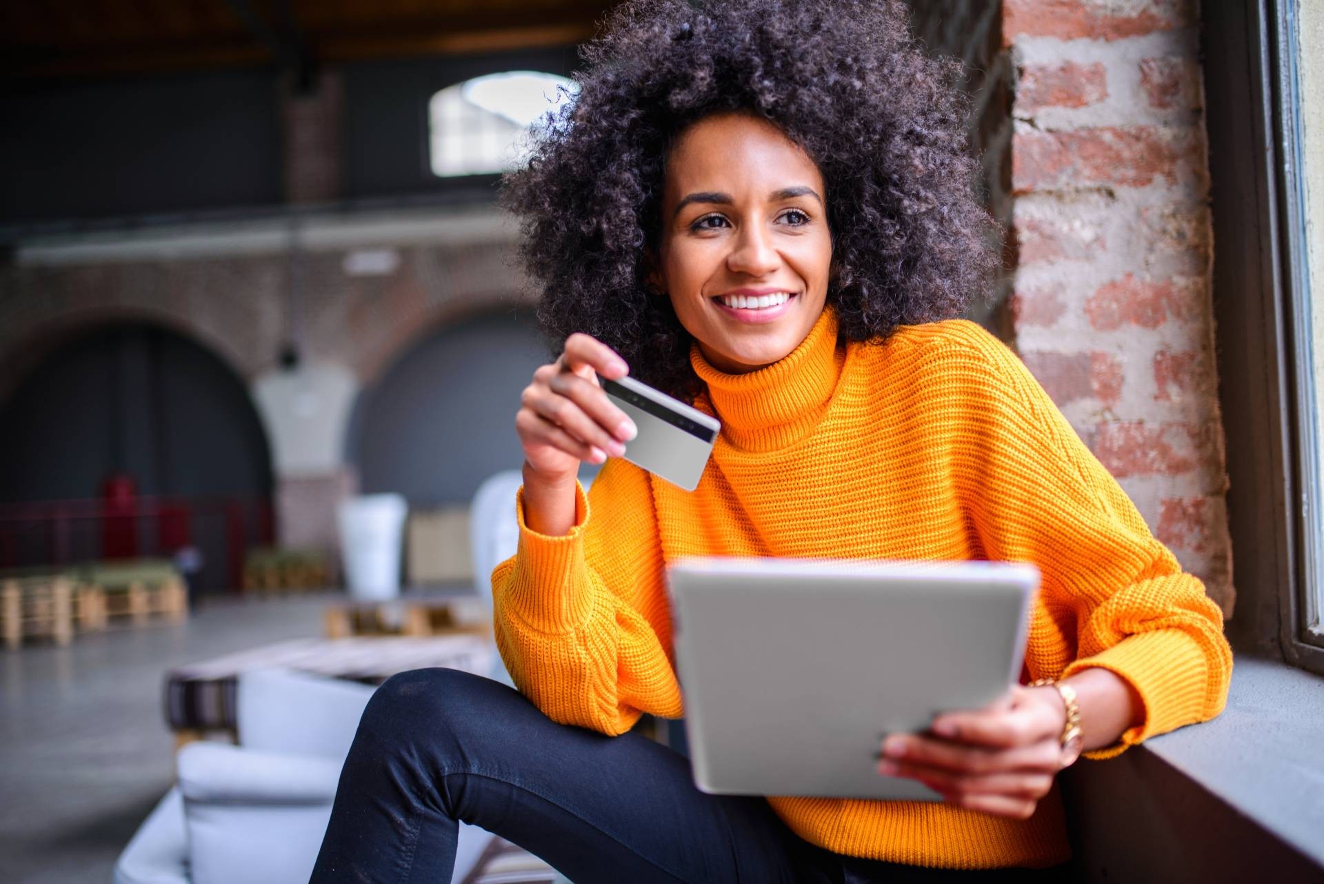 Lady on laptop holding credit cards